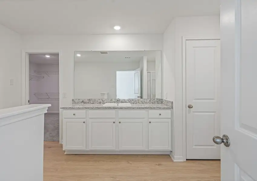 Spacious master bathroom with a dual sink vanity and step-in shower