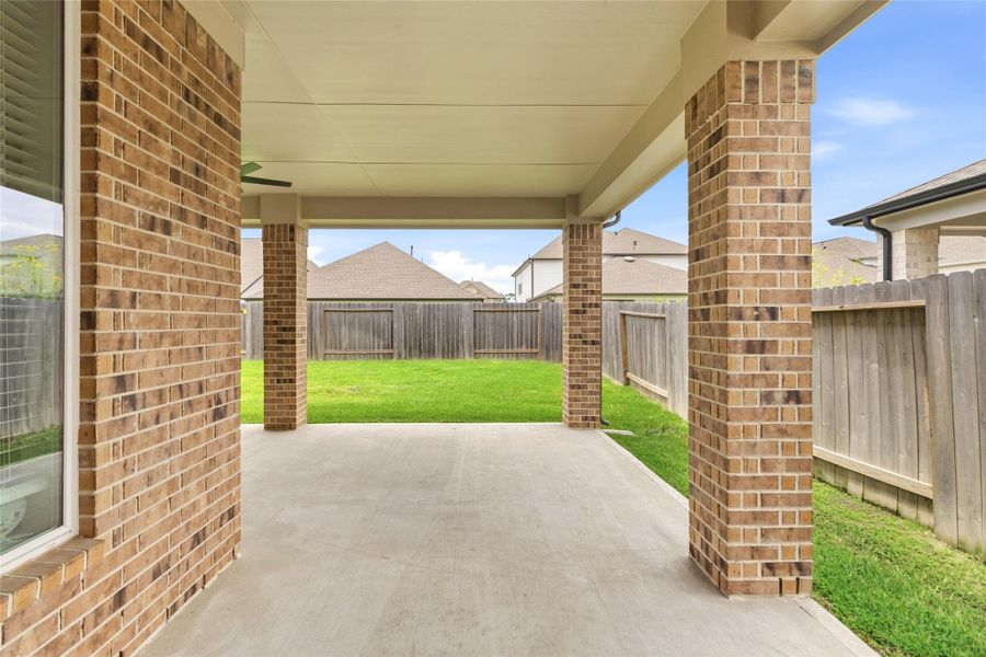 Enjoy year-round outdoor relaxation on your expansive covered patio, complete with ceiling fan, brick columns, and plenty of room for dining and entertaining.