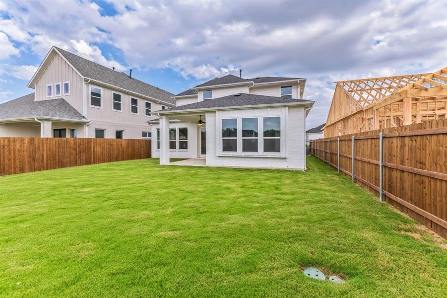 Back of house with a yard and a patio area