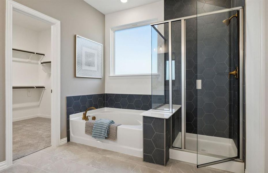 Luxurious owner's bath featuring dual vanities and a deep walk-in shower *Model representation