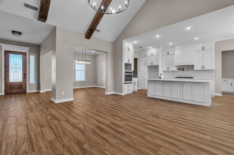 Kitchen featuring a chandelier, tasteful backsplash, recessed lighting, wood finished floors, and white cabinets Kitchen featuring a chandelier, tasteful backsplash, recessed lighting, wood finished floors, and white cabinets