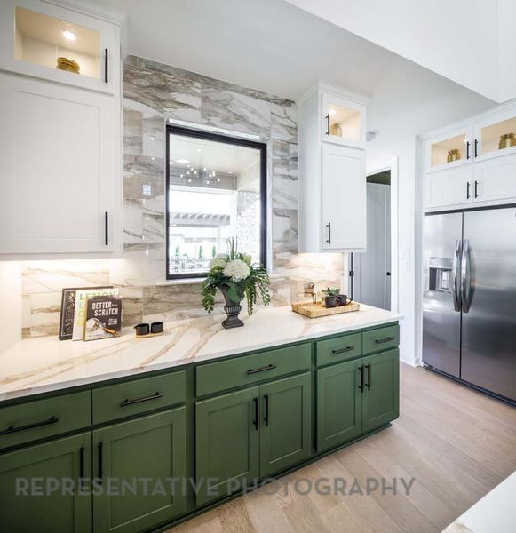 Kitchen featuring green cabinetry, stainless steel fridge, white cabinetry, and light wood-type flooring