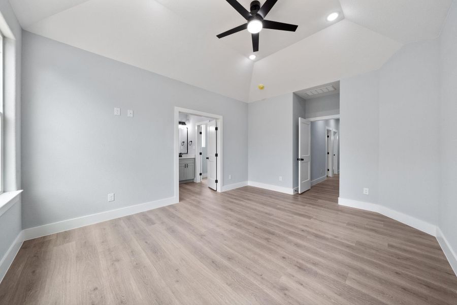 Spacious room featuring vaulted ceilings with recessed lighting and a ceiling fan