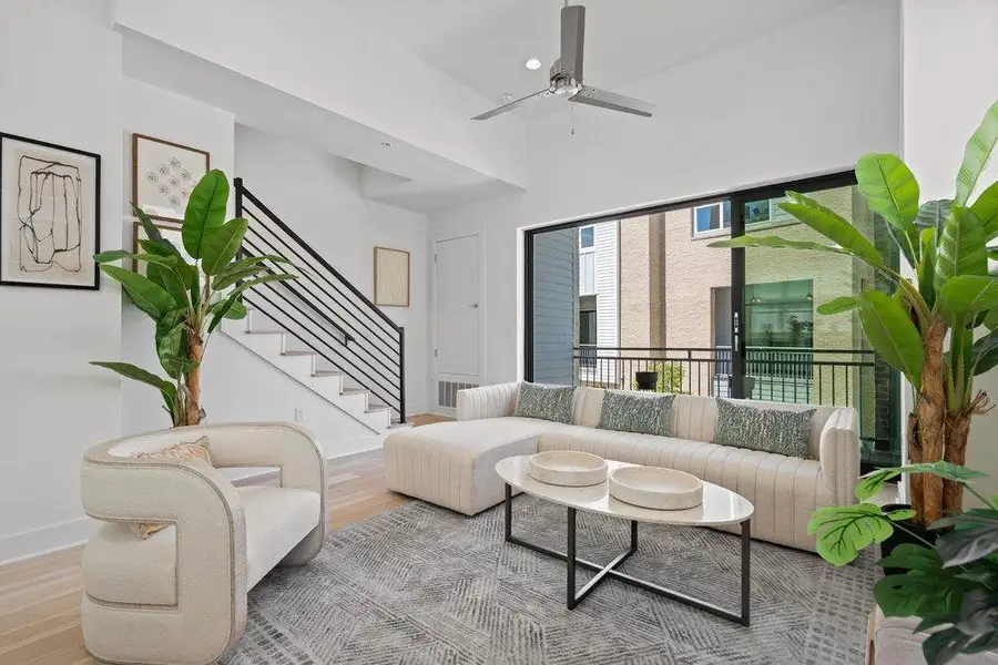 Natural light floods this inviting living area, showcasing its soaring ceilings and a private balcony. Natural light floods this inviting living area, showcasing its soaring ceilings and a private balcony.