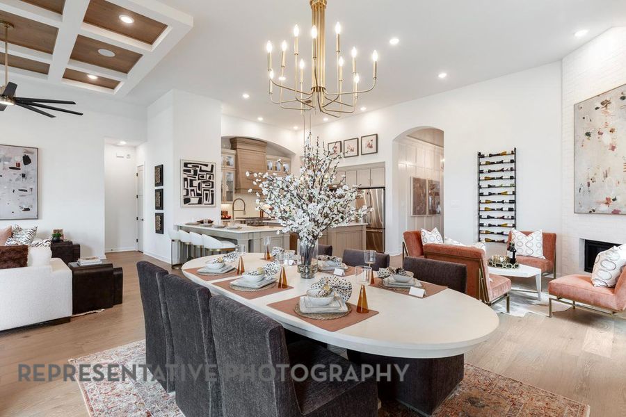 Dining area with arched walkways, light wood-style floors, a fireplace, and recessed lighting