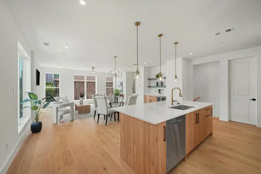 Open-concept living area featuring light wood-finish flooring, recessed lighting, and ample natural light from multiple windows Open-concept living area featuring light wood-finish flooring, recessed lighting, and ample natural light from multiple windows