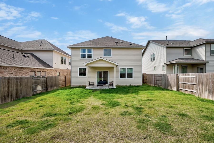 Two-story residence with a covered patio and sliding glass door access to the backyard
