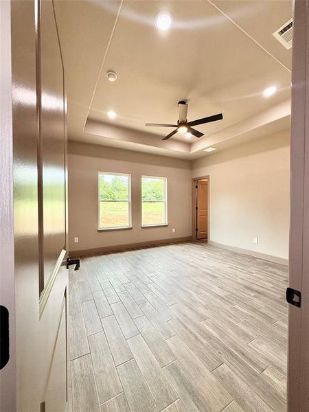 Primary bedroom featuring custom altar style ceilings, with remote controlled lighting and natural light with a view of the spacious backyard Primary bedroom featuring custom altar style ceilings, with remote controlled lighting and natural light with a view of the spacious backyard