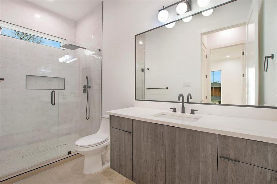 Full bath with a shower stall, vanity, toilet, and tile patterned floors Full bath with a shower stall, vanity, toilet, and tile patterned floors