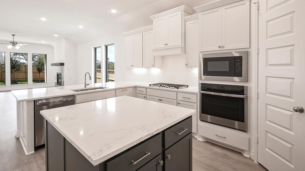 Kitchen with a peninsula, recessed lighting, appliances with stainless steel finishes, backsplash, and white cabinetry Kitchen with a peninsula, recessed lighting, appliances with stainless steel finishes, backsplash, and white cabinetry