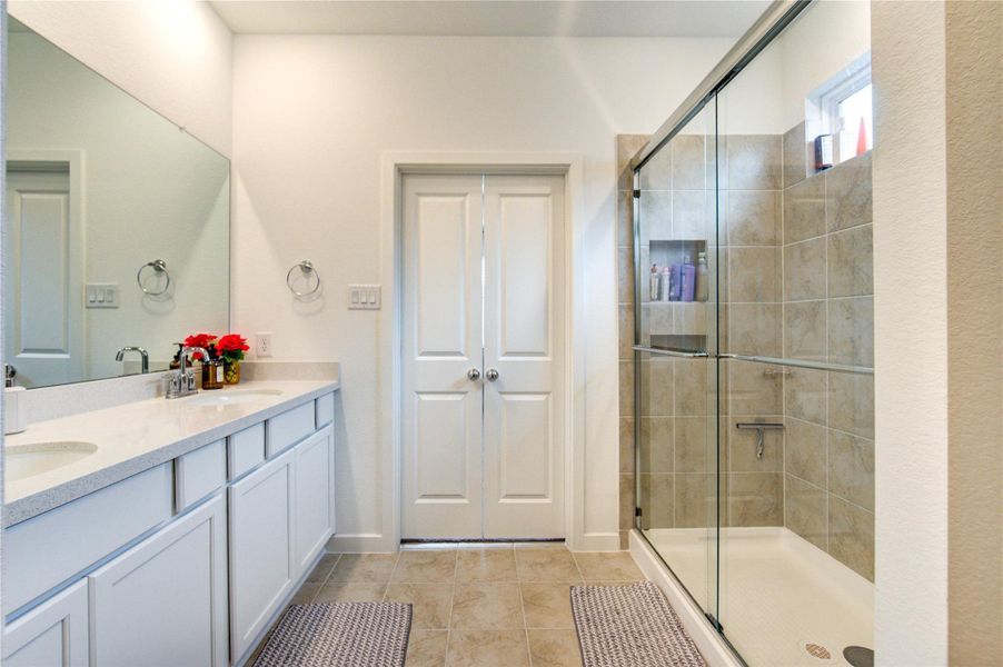 The primary bath offers a refined retreat designed for comfort and ease, featuring a well-appointed layout that enhances both functionality and style. The combination of a sleek glass-enclosed shower and spacious vanity area provides a relaxing setting for daily routines, making this bath a perfect extension of the tranquil primary suite.