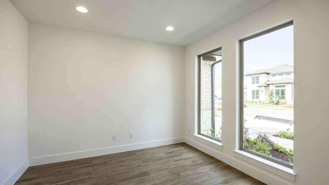 Empty room featuring baseboards, wood finished floors, and recessed lighting Empty room featuring baseboards, wood finished floors, and recessed lighting