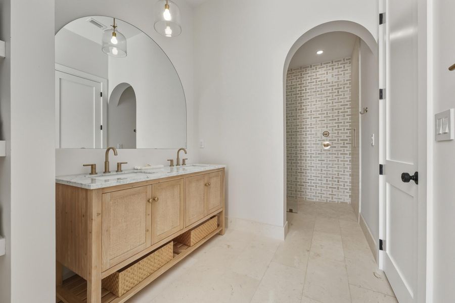 Arched entrance into massive shower & toilet area