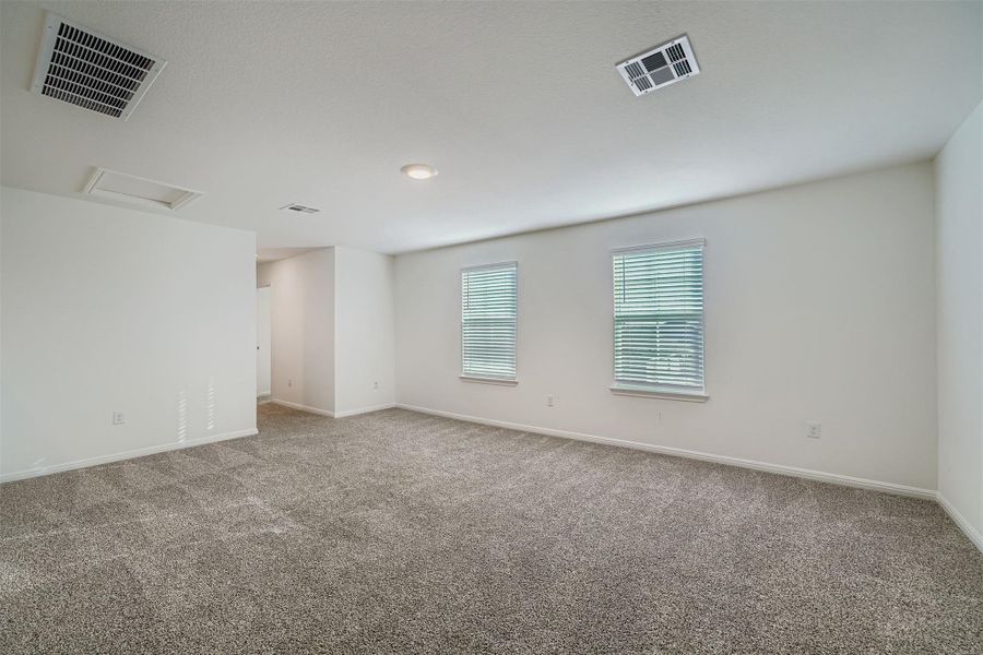 Unfurnished room with attic access and carpet