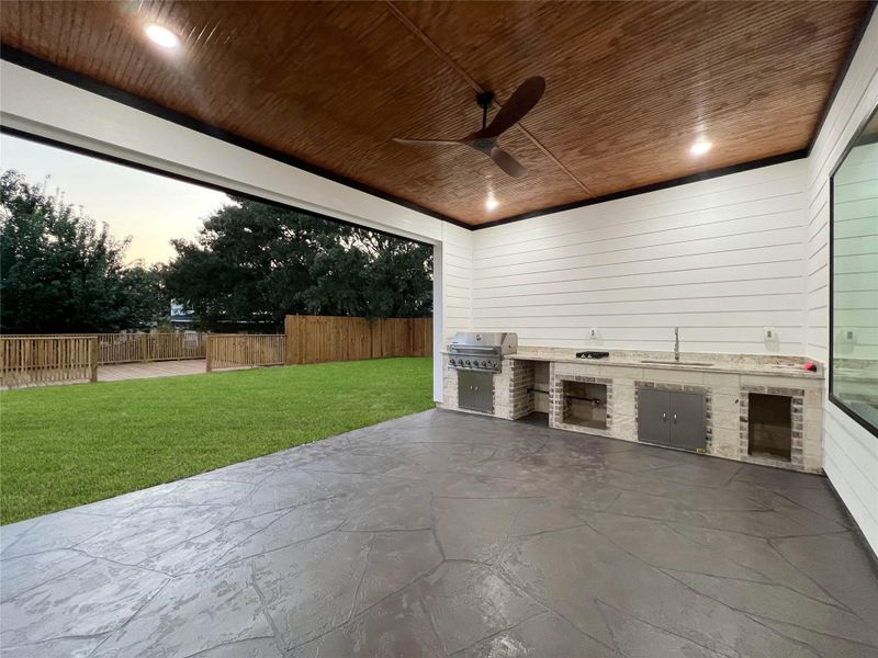 The large backyard with wood deck and outdoor kitchen is the perfect al fresco entertaining space.