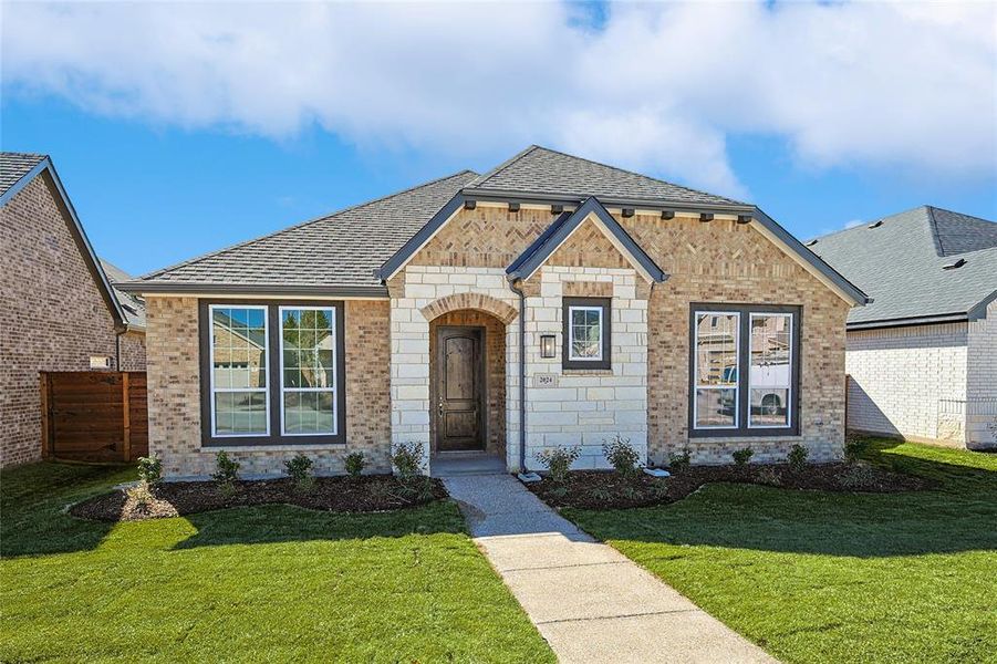 French country style house with brick siding and a shingled roof