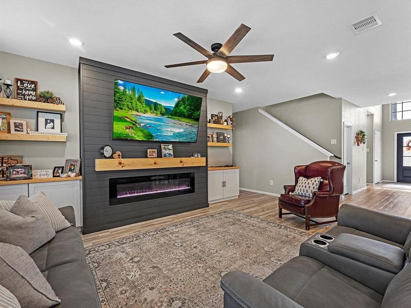 Custom cabinets/shelves surround the sleek faux fire place addition.