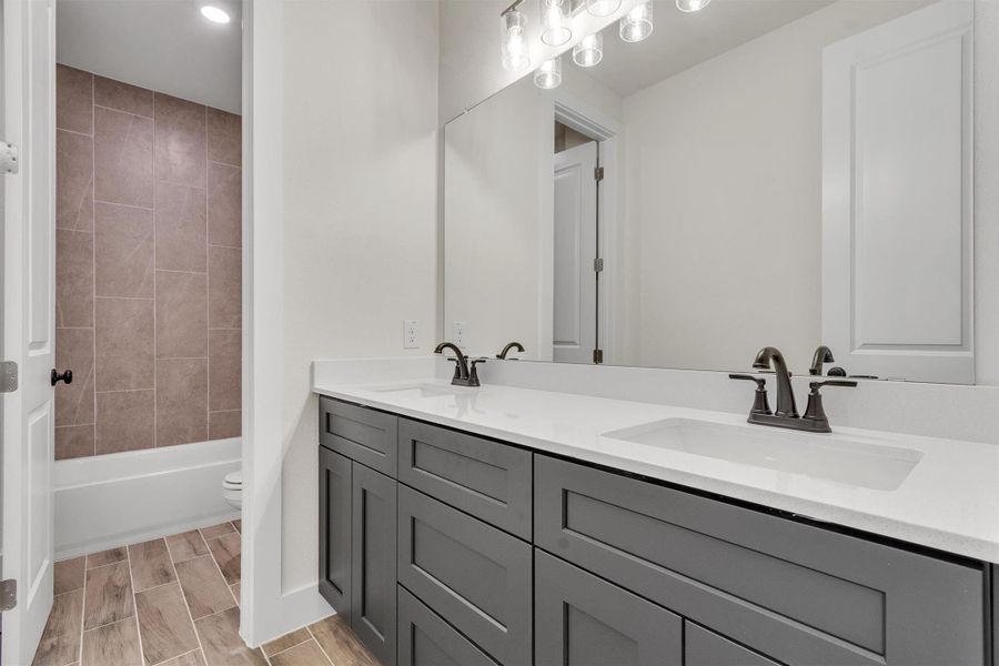Dual vanities with ample counter space offer practical elegance for daily routines.