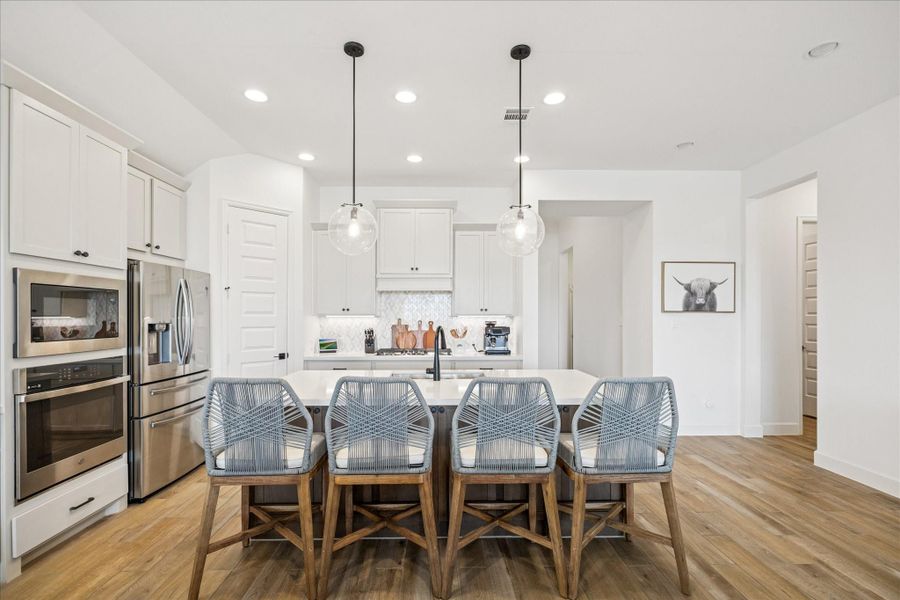 Light accents, quartz countertops and a breakfast bar.