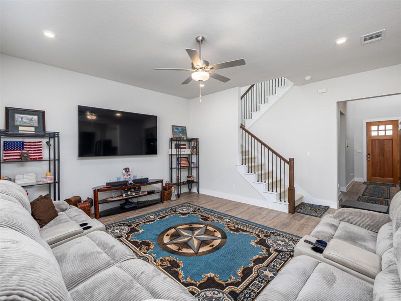 Living area featuring wood finished floors, ceiling fan, and recessed lighting