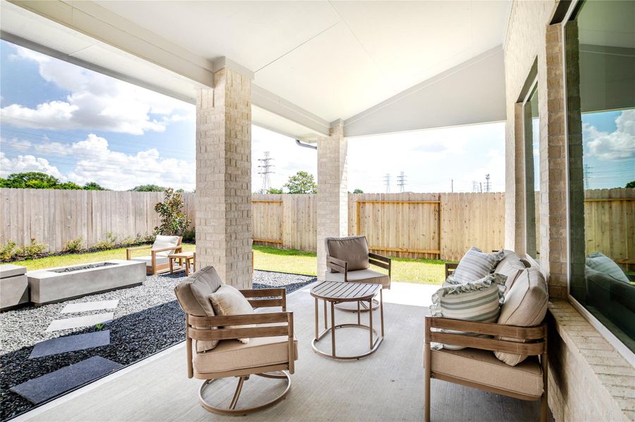 This photo showcases a modern, covered patio with sprinkler system overlooking a fenced backyard. This photo showcases a modern, covered patio with sprinkler system overlooking a fenced backyard.