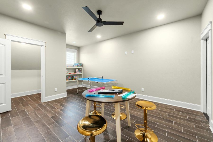 Spacious room featuring wood-finish flooring, recessed lighting, and a contemporary ceiling fan