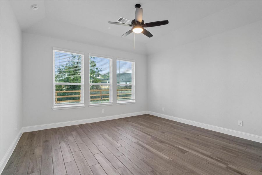 Relax and unwind after a long day in this impressive primary suite! This generously sized room offers wood-look tile flooring, neutral-toned paint, high ceilings with a ceiling fan, and large windows for added comfort and tranquility. Relax and unwind after a long day in this impressive primary suite! This generously sized room offers wood-look tile flooring, neutral-toned paint, high ceilings with a ceiling fan, and large windows for added comfort and tranquility.