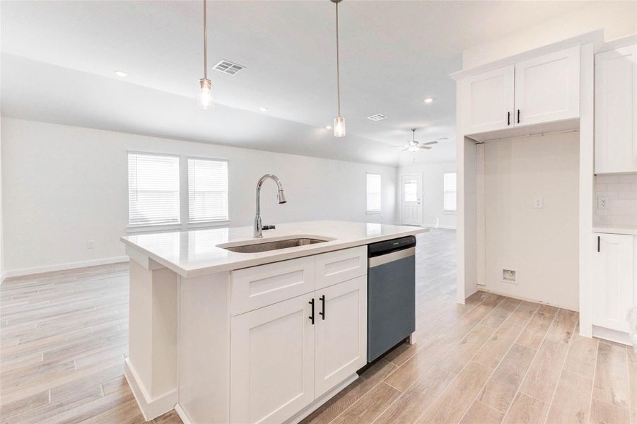 The oversized quartz island anchors this stylish kitchen with a deep undermount sink, built-in dishwasher, and ample storage. Sleek pendant lighting adds a designer touch while providing soft ambiance. With views to the expansive living space, this setup is perfect for entertaining, serving, or simply enjoying everyday life. The oversized quartz island anchors this stylish kitchen with a deep undermount sink, built-in dishwasher, and ample storage. Sleek pendant lighting adds a designer touch while providing soft ambiance. With views to the expansive living space, this setup is perfect for entertaining, serving, or simply enjoying everyday life.