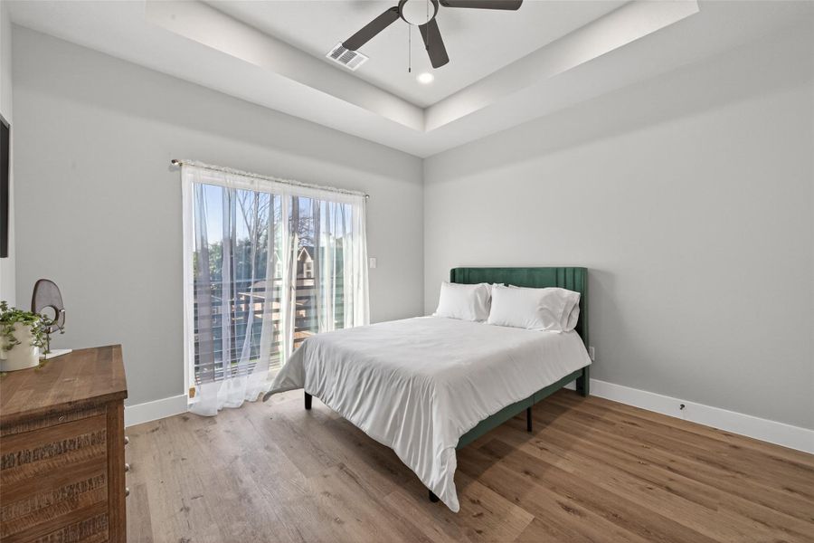 Alternate primary suite view highlighting the generous room scale, crisp designer paint palette, and seamless white oak–tone plank flooring—creating a calm, sophisticated atmosphere ideal for rest and relaxation.