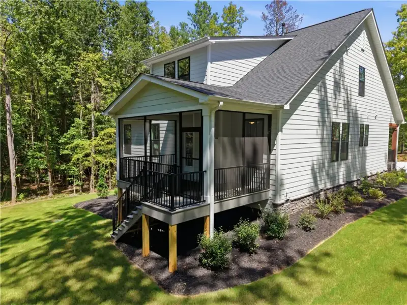 A spacious screened porch overlooks the lush, wood