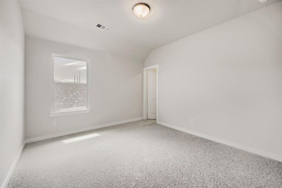 Bedroom featuring light gray walls, gray carpet flooring, a single window, and a white paneled door