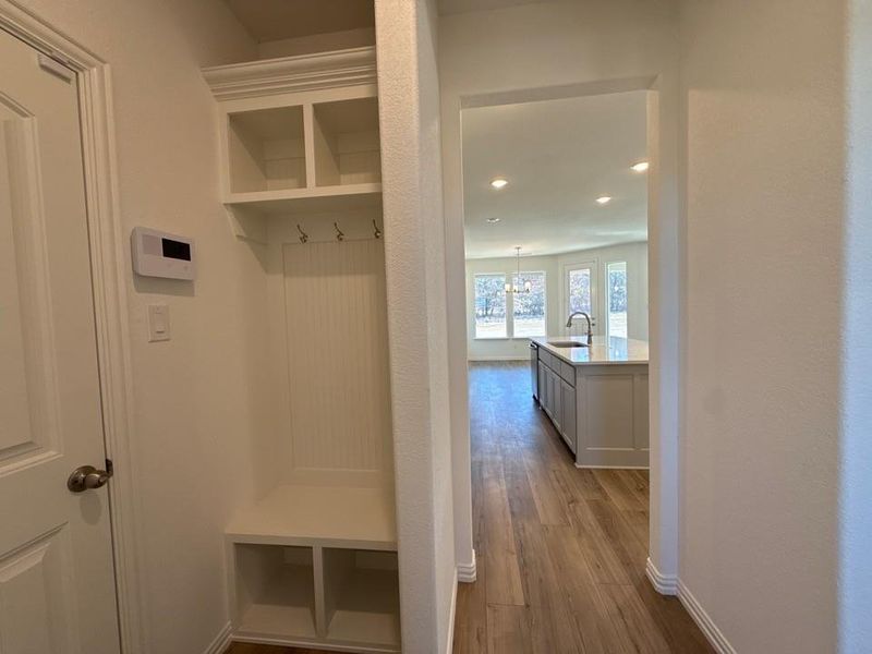 Mudroom featuring dark wood-style floors and a chandelier