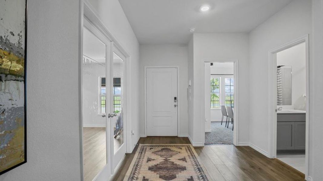 Entryway featuring dark wood-style floors, french doors, and recessed lighting