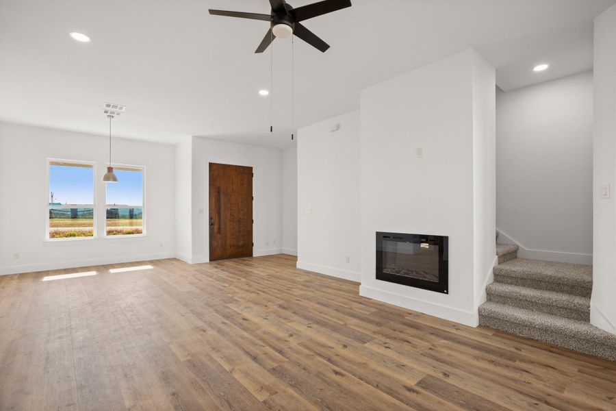 A grand wooden entry door welcomes you into this spacious living area with an electric fireplace. A grand wooden entry door welcomes you into this spacious living area with an electric fireplace.