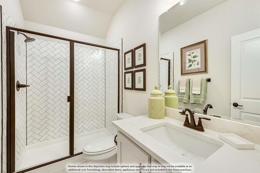 Bathroom with herringbone tile shower, glass door, white vanity, and bronze fixtures