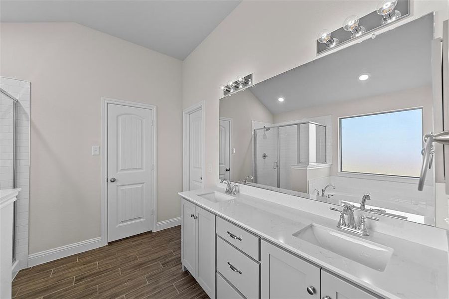 Bathroom with vanity, separate shower and tub, hardwood / wood-style floors, and vaulted ceiling