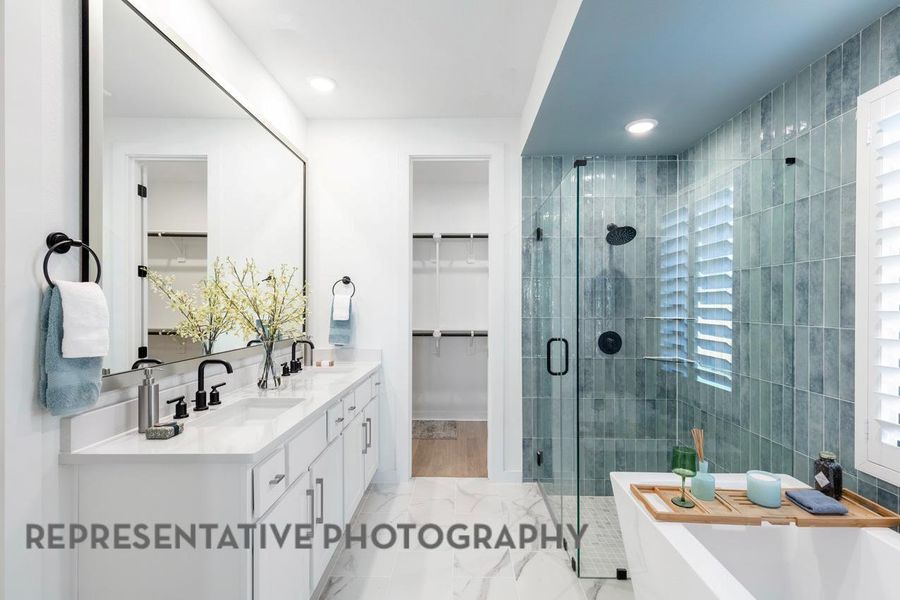 Full bath featuring a spacious closet, double vanity, a shower stall, a soaking tub, and marble finish floors Full bath featuring a spacious closet, double vanity, a shower stall, a soaking tub, and marble finish floors