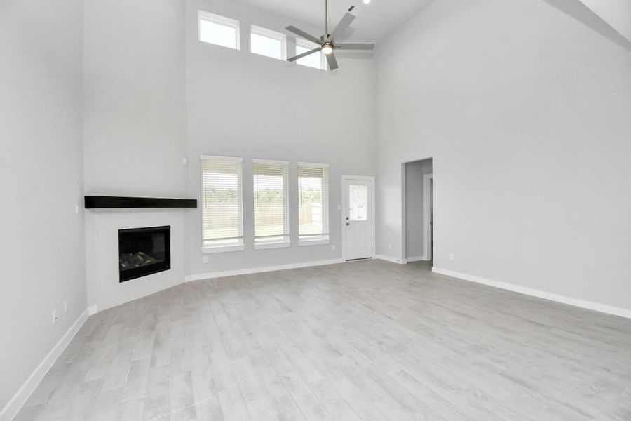 Gather the family and guests together in your lovely living room! Featuring soaring high ceilings, recessed lighting, ceiling fan, custom paint, gorgeous floors, and large windows that provide plenty of natural lighting throughout the day. Gather the family and guests together in your lovely living room! Featuring soaring high ceilings, recessed lighting, ceiling fan, custom paint, gorgeous floors, and large windows that provide plenty of natural lighting throughout the day.