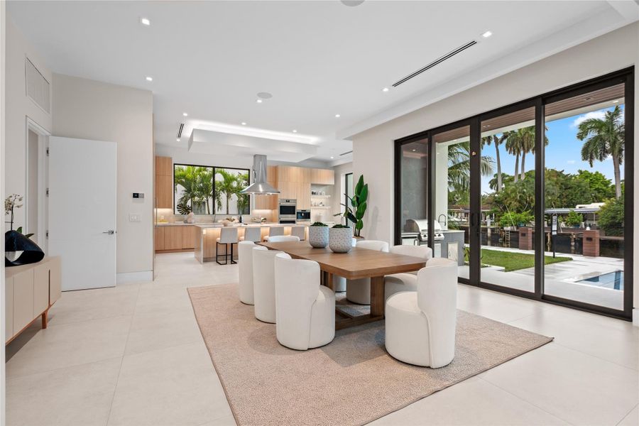 Open dining area with floor-to-ceiling glass doors, sleek modern design, and seamless flow to the chef’s kitchen and outdoor entertaining spaces. Open dining area with floor-to-ceiling glass doors, sleek modern design, and seamless flow to the chef’s kitchen and outdoor entertaining spaces.