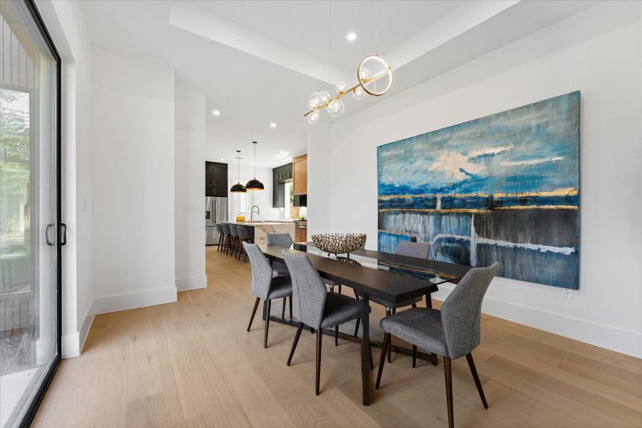 Spacious dining room featuring elegant lighting, and an open layout to the kitchen and living room, perfect for entertaining. Spacious dining room featuring elegant lighting, and an open layout to the kitchen and living room, perfect for entertaining.