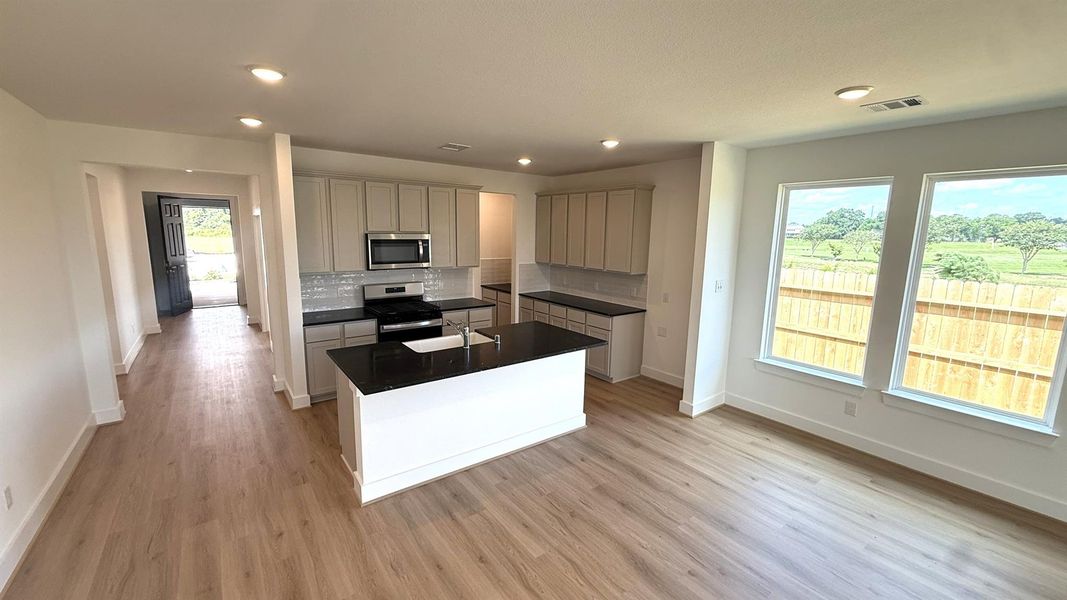 Natural light pours in through large windows, creating a bright and airy atmosphere that makes cooking feel less like a chore and more like a delightful experience.