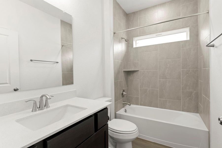 Full bath with bathing tub / shower combination, vanity, and dark wood-style floors