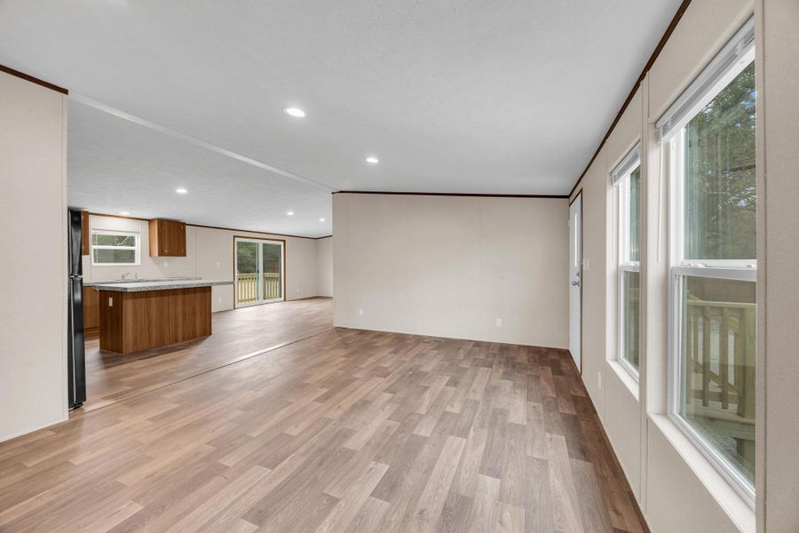 Unfurnished living room with light wood finished floors, recessed lighting, and ornamental molding
