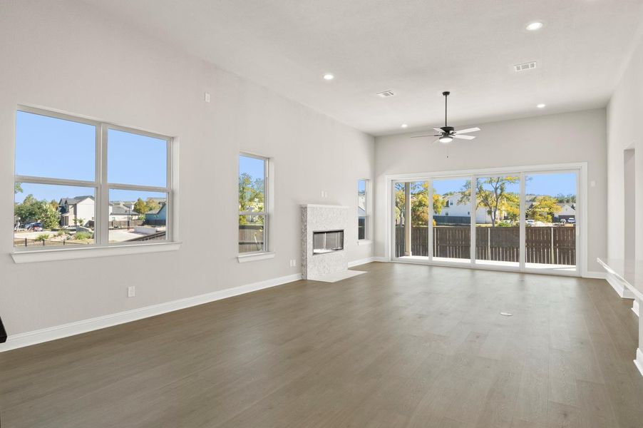 Unfurnished living room with a premium fireplace, recessed lighting, wood finished floors, and ceiling fan Unfurnished living room with a premium fireplace, recessed lighting, wood finished floors, and ceiling fan