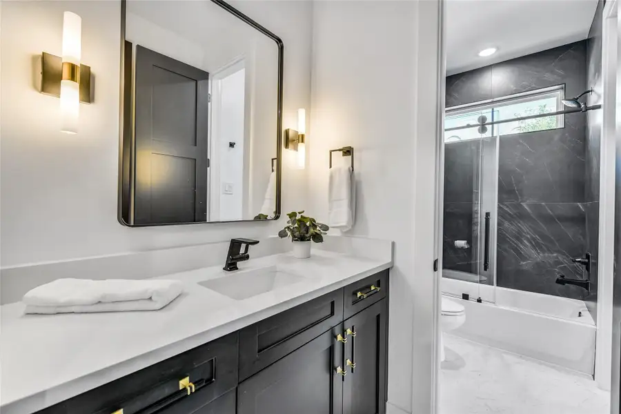 A statement in contemporary luxury, this spa-inspired bath showcases custom cabinetry with soft-close drawers, sleek quartz countertops, and brushed gold fixtures. The floor-to-ceiling marble tile shower/tub surround exudes sophistication, while the lighting design enhances the calm, restorative aesthetic—perfect for unwinding after along shift at the hospital or clinic. A statement in contemporary luxury, this spa-inspired bath showcases custom cabinetry with soft-close drawers, sleek quartz countertops, and brushed gold fixtures. The floor-to-ceiling marble tile shower/tub surround exudes sophistication, while the lighting design enhances the calm, restorative aesthetic—perfect for unwinding after along shift at the hospital or clinic.