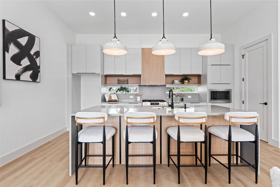 Intentional clerestory windows brighten the kitchen’s clean lines, with a walk-in pantry tucked just beyond the right-hand door. Intentional clerestory windows brighten the kitchen’s clean lines, with a walk-in pantry tucked just beyond the right-hand door.