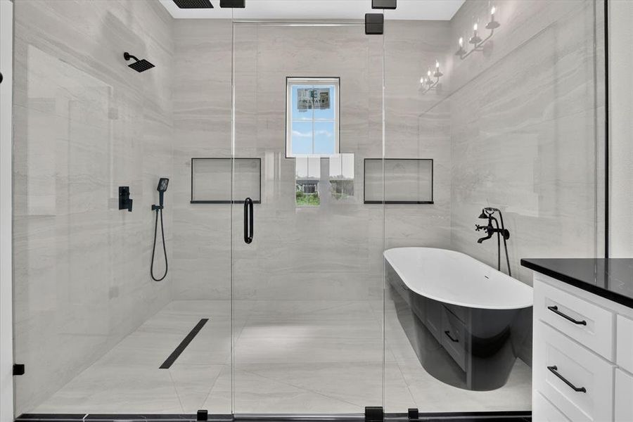 Glass-enclosed shower with matte black fixtures, integrated linear drain, and dual showerheads