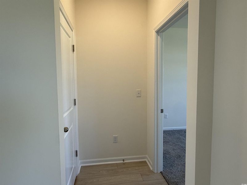 Kitchen featuring stainless steel gas range oven, light wood-style floors, dark stone counters, and white cabinets Kitchen featuring stainless steel gas range oven, light wood-style floors, dark stone counters, and white cabinets