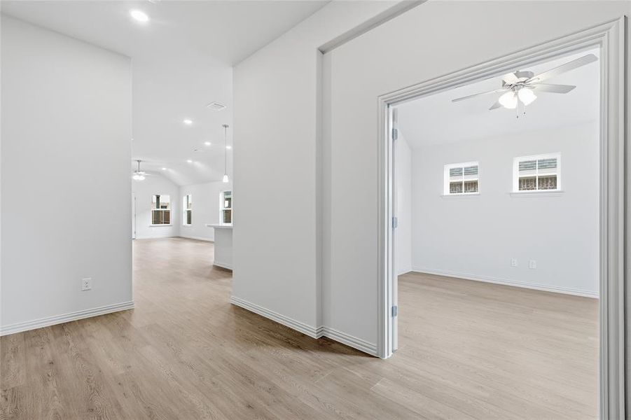 Hall with recessed lighting, light wood finished floors, plenty of natural light, and vaulted ceiling