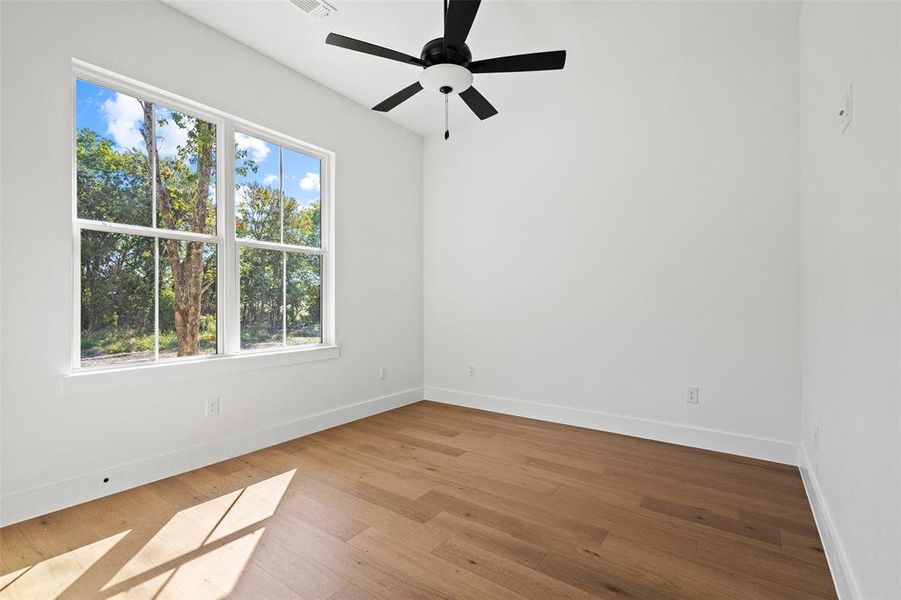 Empty room featuring hardwood / wood-style floors and ceiling fan Empty room featuring hardwood / wood-style floors and ceiling fan